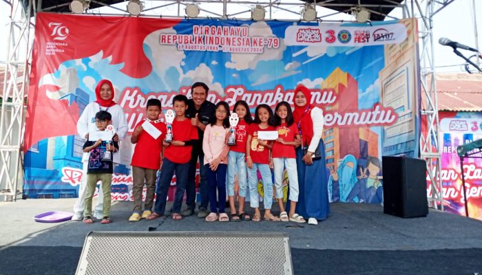 Ket foto : Ketua RW 07, Chodel Wardi, saat foto bersama anak di sesi pemberian piala lomba mewarnai. (dok. Harianesia.com)