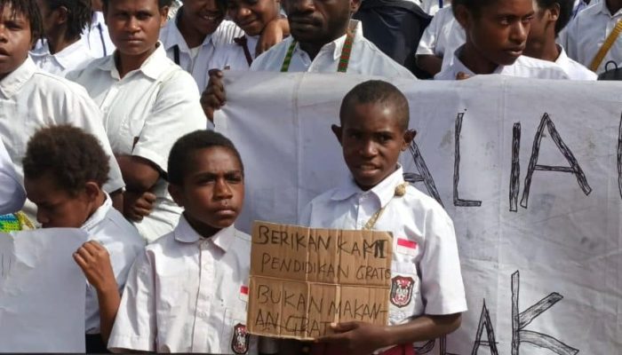 Siswa siswi SD disalah satu sekolah di Kabupaten Paniai saat memegang Pamflet bertuliskan "berikan kami pendidikan gratis bukan makanan gratis, " Senin (24/2/2025) - Doc. Aliansi Pelajar